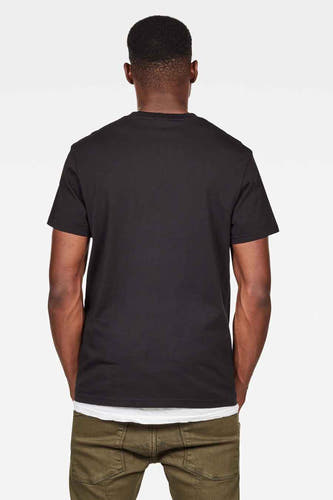 T-shirt noir de G-Star RAW, à manches courtes, vu de derrière, associé à une top blanche et un pantalon vert.