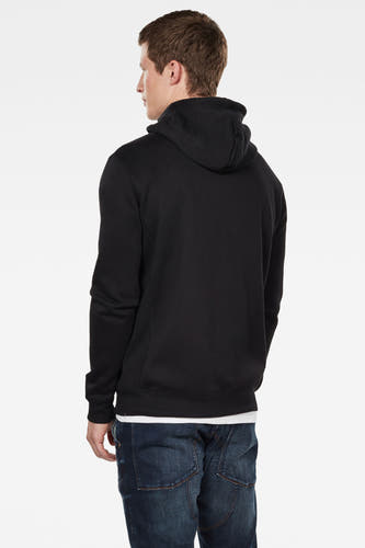 Gilet-sweat noir de G-Star RAW, avec capuchon, porté par-dessus un t-shirt blanc et un jean bleu, vu de dos.