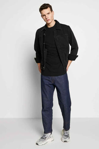 T-shirt noir de G-Star RAW, porté avec un manteau noir et des jeans bleu marine.