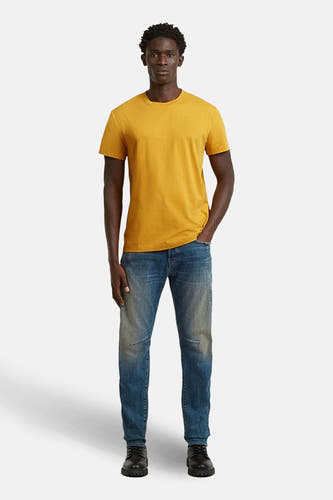 T-shirt à manches courtes jaune de G-Star RAW, porté avec un jean bleu et des chaussures noires.
