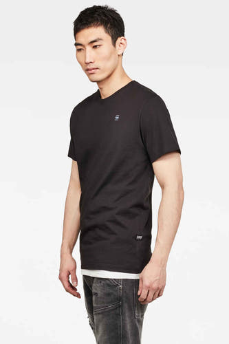 T-shirt noir de G-Star RAW, avec des manches courtes et une petite impression logo, porté avec un jean gris.