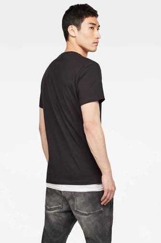 T-shirt noir de G-Star RAW, montré par derrière, associé à un chemisier blanc et des jeans gris.