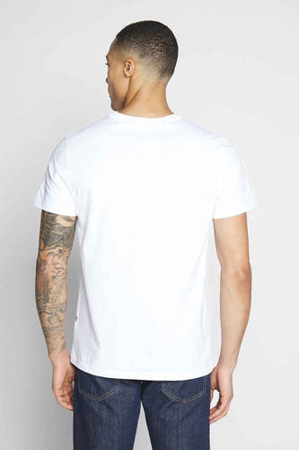 Wit T-shirt van G-Star RAW, achterkant, met een tatoeage op de linkerarm en blauwe jeans.