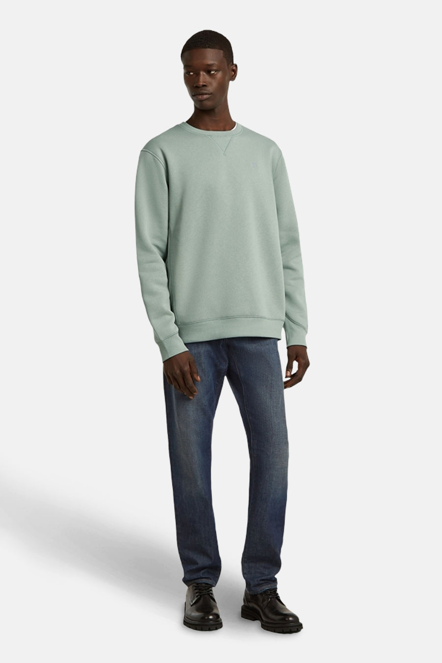Sweater vert de G-Star RAW, associé à des jeans noirs et des chaussures noires.