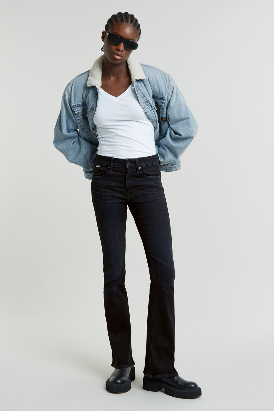 Jean flare noir de G-Star RAW, associé à une chemise blanche, un manteau en denim avec une doublure en fourrure et des chaussures noires.