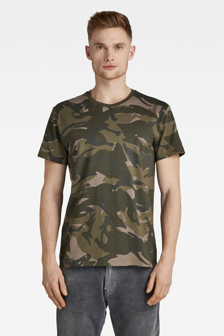 T-shirt de camouflage vert de G-Star RAW, avec des manches courtes et un jean gris.