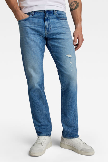 Jean bleu droit de G-Star RAW, arrière, avec des poches classiques et des baskets blanches.