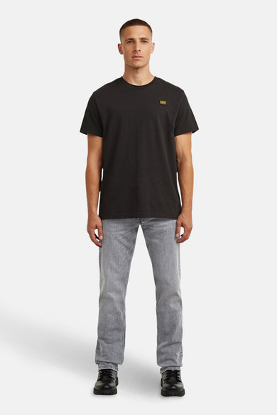 Jean droit gris de G-Star RAW, associé à un t-shirt noir et des chaussures noires.