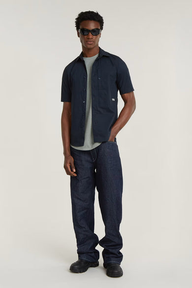 Chemise noire à manches courtes de G-Star RAW, portée avec un t-shirt gris et des jeans bleu marine.