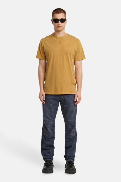 T-shirt jaune à manches courtes de G-Star RAW, porté avec un jeans foncé et des chaussures noires.