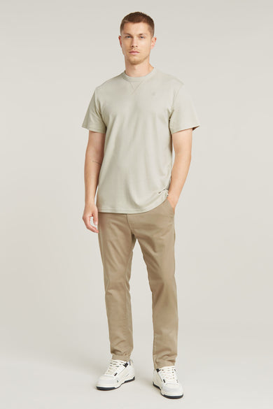 T-shirt écru à manches courtes de G-Star RAW, associé à des chinos et des baskets blanches.