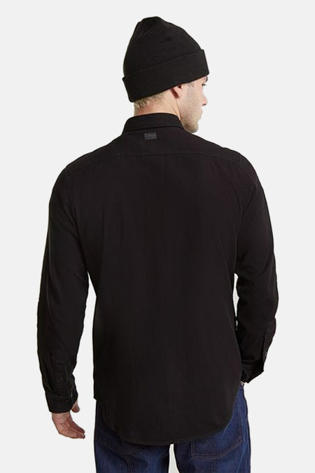 Grijs overhemd met lange mouwen van G-Star RAW, gezien van achteren, gecombineerd met een zwarte muts en een donkerblauwe broek.