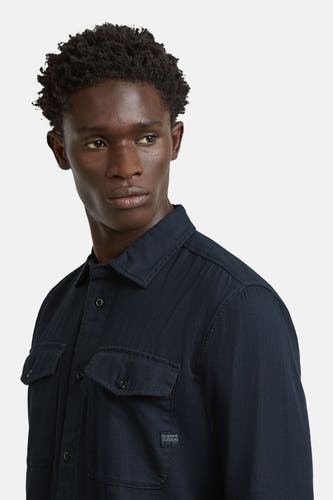 Chemise bleue à manches longues G-Star RAW, avec poches poitrine et une teinte foncée.