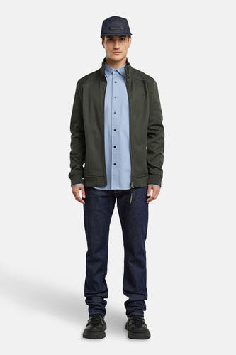 Chemise bleue à manches longues de G-Star RAW, portée avec une veste verte et des jeans bleu marine.