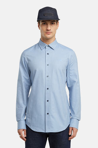 Chemise bleue à manches longues de G-Star RAW, portée avec un chapeau bleu marine.