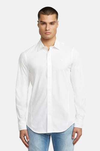 Blouse blanche à manches longues de G-Star RAW, portée avec des jeans et des chaussures noires.