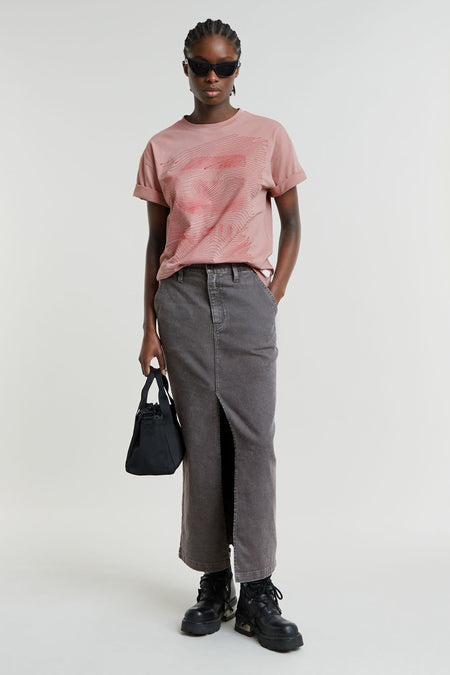 Jupe longue en denim gris moyen de G-Star RAW avec une fente haute à l'avant, stylisée avec un t-shirt rose et des bottes noires.