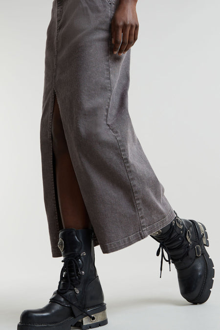 Jupe longue en denim gris moyen de G-Star RAW avec une fente à l'avant, portée avec des bottes noires.
