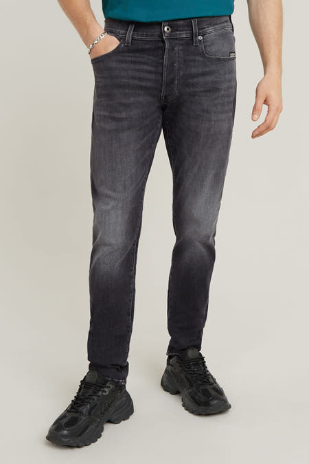 Jean slim de denim gris foncé G-Star RAW RAW, une une sublage et portée avec des sneakers noires.