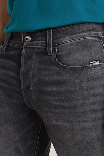 Jean slim de denim gris foncé de G-Star RAW, avec un lavage subtil et une petite étiquette de marque sur la poche.
