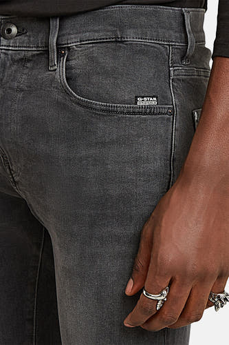 Jean skinny gris G-Star RAW, avec un main et des anneaux en argent.