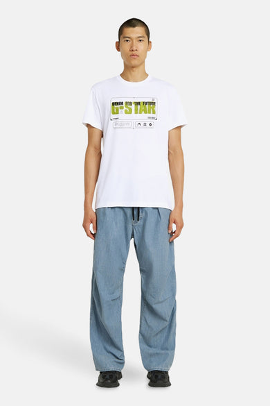 Wit T-shirt met korte mouwen van G-Star RAW, met opdruk op de borst, gecombineerd met losse blauwe jeans en zwarte schoenen.
