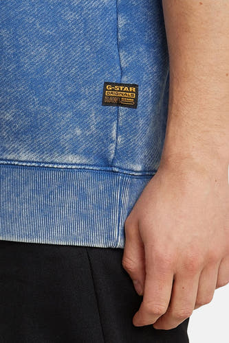 Pull-over bleu de G-Star RAW, avec un effet acid wash et une bordure côtelée.