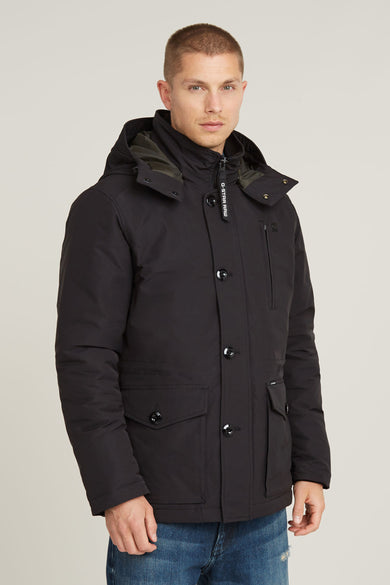 Manteau long noir de G-Star RAW, avec capuche, manches longues et pantalon en denim visible.