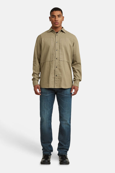 Chemise beige de G-Star RAW, à manches longues, fermeture boutonnée et poches poitrine, combinée avec un jean et des chaussures noires.