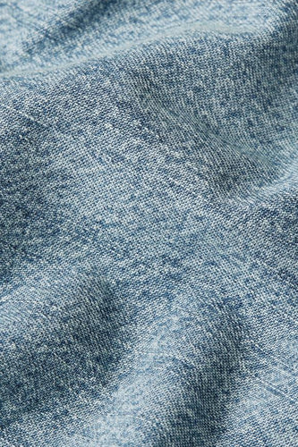 Close-up van een blauwe denim stof met textuur.
