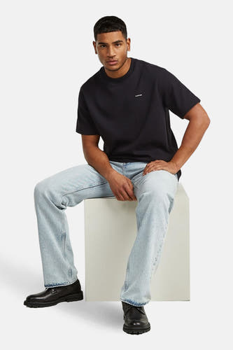 Zwart T-shirt met korte mouwen van G-Star RAW, gedragen met lichtblauwe jeans en zwarte leren schoenen.