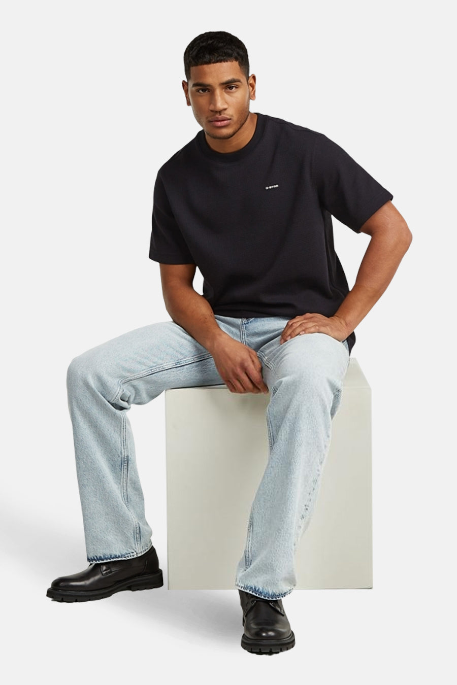 Zwart T-shirt met korte mouwen van G-Star RAW, gedragen met lichtblauwe jeans en zwarte leren schoenen.