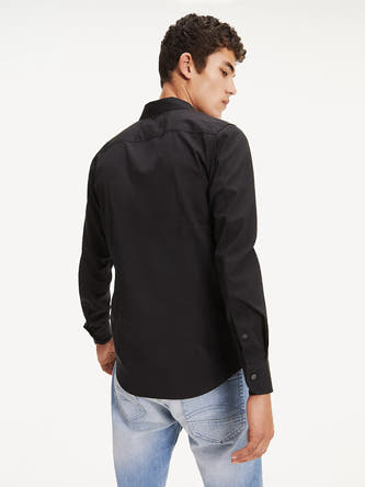 Zwart overhemd met lange mouwen van TOMMY JEANS, achterkant weergegeven, gedragen met een jeans.