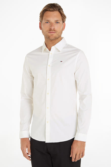 Chemise blanche à manches longues de TOMMY JEANS, avec col boutonné et un petit logo sur la poitrine.