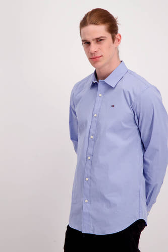 Chemise bleue à manches longues de TOMMY JEANS, avec une coupe slim et des boutons blancs.