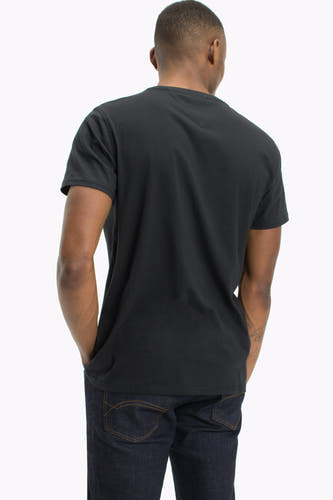 Zwart T-shirt van TOMMY JEANS, gezien van achteren, met korte mouwen en gedragen met een donkere jeans.
