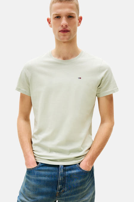 T-shirt vert de man mantes cour TOM Tommy TOM par JE JE, porté avec un jeans bleu et les mains dans les poches.