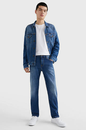 Blauwe rechte jeans van TOMMY JEANS, gecombineerd met een wit T-shirt en een denim jas.