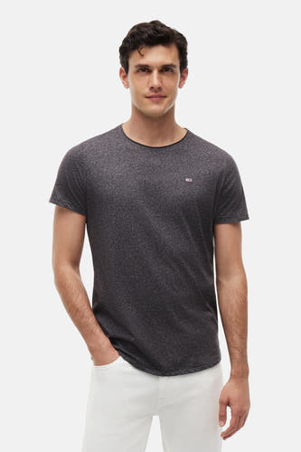 T-shirt noir chiné de TOMMY JEANS avec col rond et petit logo sur la poitrine, porté par un mannequin dans une photo lifestyle