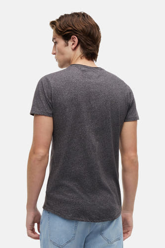 T-shirt noir de TOMMY JEANS, vu de dos, à manches courtes et coupe décontractée, porté avec un jean bleu.