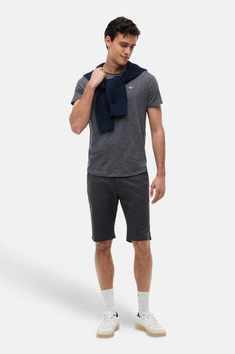 T-shirt gris chiné à manches courtes TOMMY JEANS avec logo sur la poitrine, stylé avec un pull, un short et des baskets.