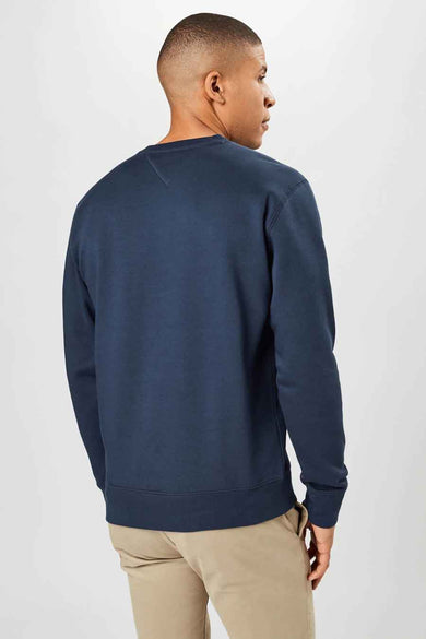 Sweat-shirt bleu de TOMMY JEANS, vue arrière, associé à un pantalon beige.