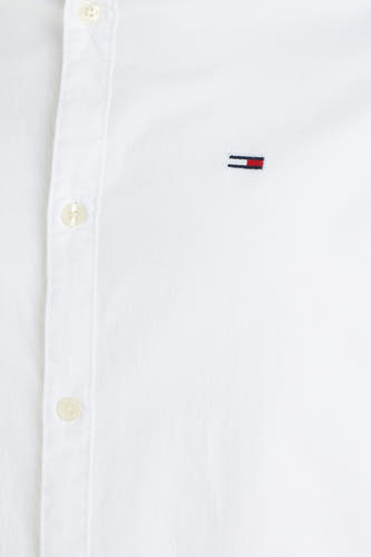 Chemise blanche à manches longues de TOMMY JEANS, avec un petit logo sur la poitrine et une fermeture à boutons.