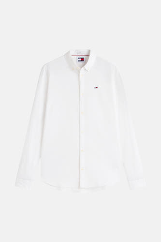 Chemise blanche à manches longues Tommy Jeans, avec un petit badge de marque sur la poitrine.
