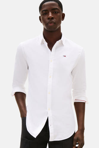 T-shirt blanc à manches longues de TOMMY JEANS, avec des manches retroussées et un logo sur la poitrine.