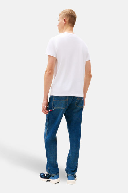 Man, achterkant, wit T-shirt, blauwe jeans, sneakers.

