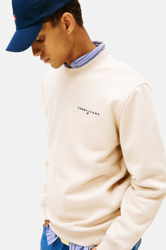 Man met blauwe pet en beige Tommy Jeans trui.