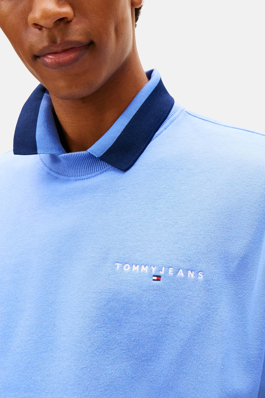 Close-up lichtblauw Tommy Jeans sweatshirt met polokraag.