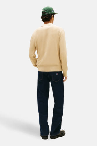 Pull beige de TOMMY JEANS, à manches longues, combiné avec un jean foncé et des chaussures noires, vu de dos.