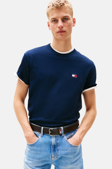 T-shirt bleu à manches courtes de Tommy Jeans, avec une enche et porté avec des jeans et une ceinture en cuir.